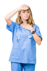 Beautiful young doctor woman wearing medical uniform over isolated background Touching forehead for illness and fever, flu and cold, virus sick