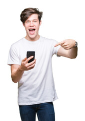 Young man using smartphone over isolated background very happy pointing with hand and finger