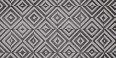 Tile pattern composed of repeating diamond shapes in shades of gray. The pattern creates an optical illusion effect, making it visually striking and dynamic. Background, wallpaper, decorative element
