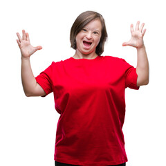 Young adult woman with down syndrome over isolated background crazy and mad shouting and yelling with aggressive expression and arms raised. Frustration concept.