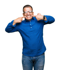 Fototapeta premium Middle age arab man wearing glasses over isolated background smiling confident showing and pointing with fingers teeth and mouth. Health concept.