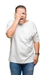 Middle age arab man wearig white t-shirt over isolated background covering one eye with hand with confident smile on face and surprise emotion.