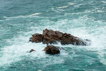 Aerial View of Waves Crashing Against Rocks