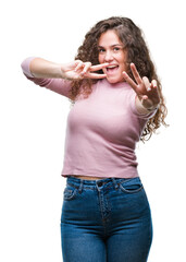 Beautiful brunette curly hair young girl wearing pink sweater over isolated background smiling looking to the camera showing fingers doing victory sign. Number two.