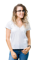 Beautiful young blonde woman wearing glasses over isolated background looking away to side with smile on face, natural expression. Laughing confident.