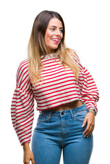 Young beautiful woman casual stripes winter sweater over isolated background looking away to side with smile on face, natural expression. Laughing confident.