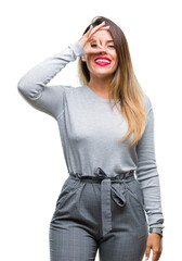 Young beautiful worker business woman over isolated background doing ok gesture with hand smiling, eye looking through fingers with happy face.