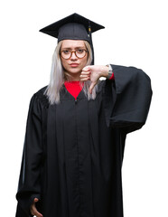 Young blonde woman wearing graduate uniform over isolated background looking unhappy and angry...