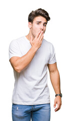 Young handsome man wearing white t-shirt over isolated background bored yawning tired covering mouth with hand. Restless and sleepiness.