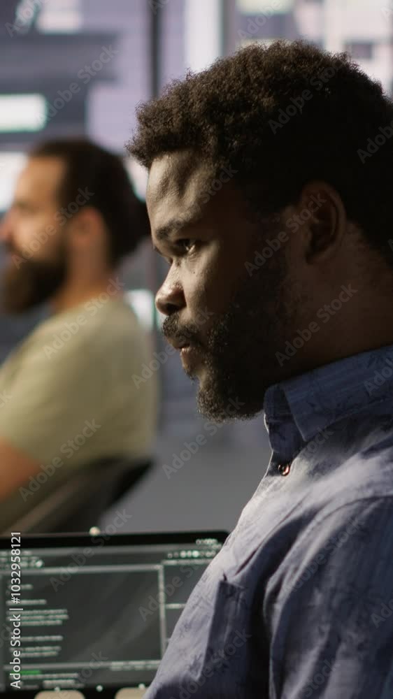 Poster vertical video programmer waiting for coworker to come help him fix applications issues, dealing wit