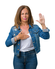 Beautiful middle age woman wearing casual denim jacket over isolated background Swearing with hand...