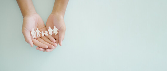 Hands holding multi generational family paper, family wellness, health insurance concept
