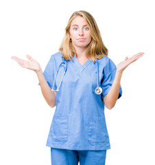 Beautiful young doctor woman wearing medical uniform over isolated background clueless and confused...