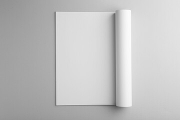 Open magazine with blank page on grey background, top view. Mockup for design