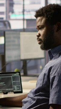 Vertical video Developer working together with helpful colleague on artificial intelligence machine learning tech, improving company systems. IT specialist assisted by coworker to compare data