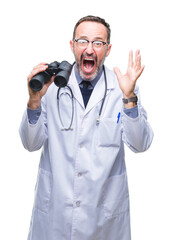 Middle age senior hoary doctor man looking through binoculars isolated background very happy and excited, winner expression celebrating victory screaming with big smile and raised hands