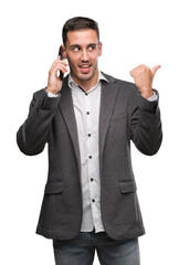 Handsome young man using smartphone pointing with hand and finger up with happy face smiling