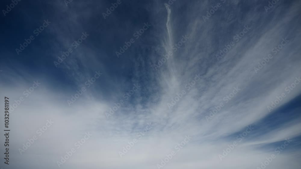 Wall mural time lapse of white clouds moving across a dark blue sky. only sky in frame