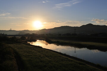 朝日が昇る日本の田舎の大きな川の風景