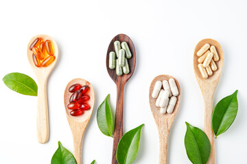 Different pills, herbs vitamin and mineral pills in wooden spoon flat lay Dietary supplements