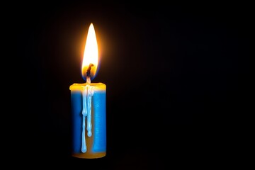 A single candle flame floating in darkness, symbolizing hope and celebration