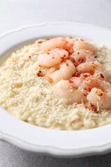 Delicious risotto with shrimps and cheese on table, closeup