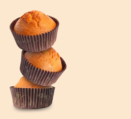 Stack of tasty muffins on beige background. Space for text