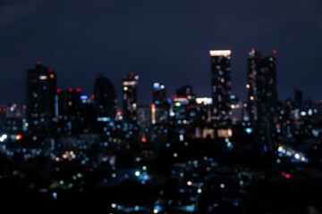 Blurred photo of skyscrapers in Bangkok cityscape at twilight time.