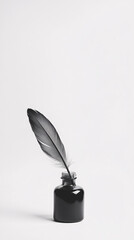 black and white still life photo of a feather in ink bottle  on a white background