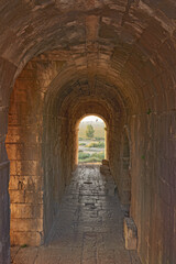 Fototapeta premium Travel, tunnel and ancient architecture as history, old building and wallpaper at destination. Landmark, monument and empire with tourism, culture and art for discovery, adventure and site in Greece