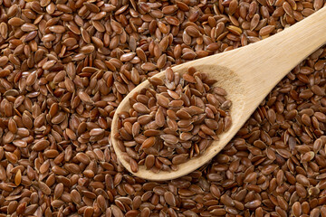 close-up a spoonful of raw flaxseeds.