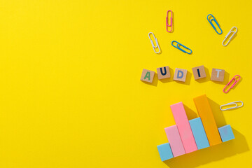 Diagram, clips and wooden cubes with letters on yellow background, space for text