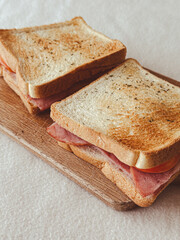Close up homemade ham cheese sandwiches served on the wooden board.