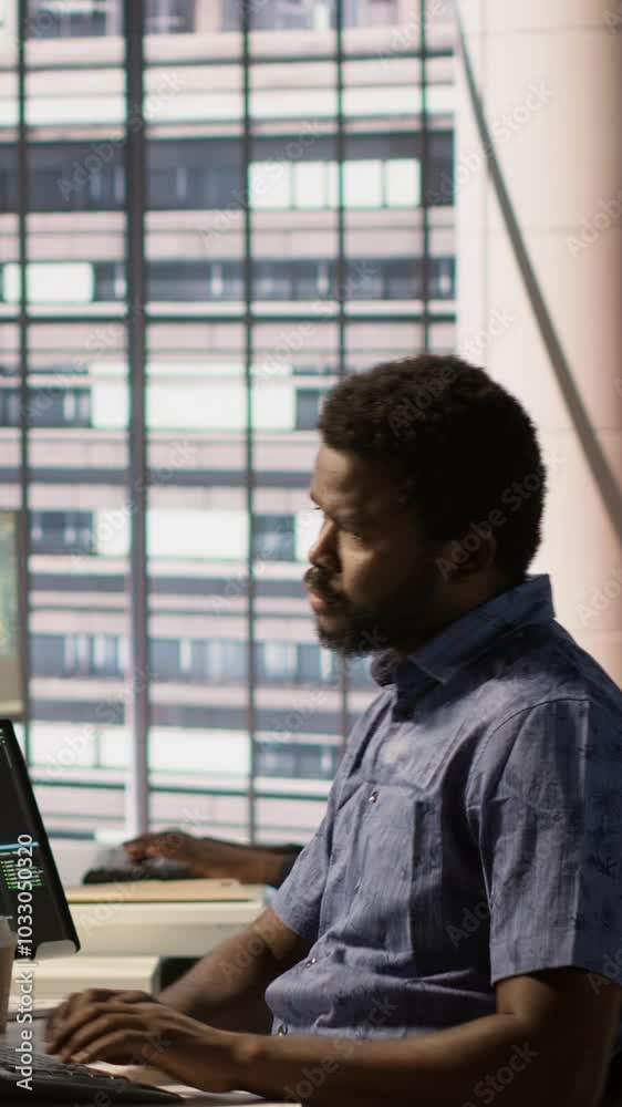 Poster vertical video tired admin stretches limbs while using pc for artificial intelligence computing simu