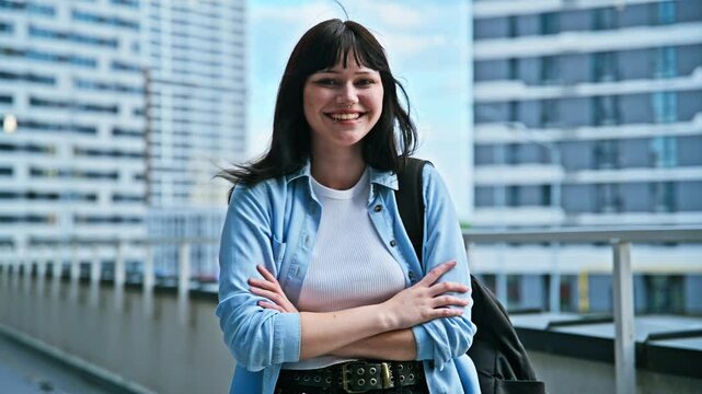 Portrait young confident female college student with backpack, crossed arms, outdoors