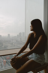 Introvert single asian woman sitting looking out the view enjoy being alone.