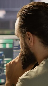 Vertical video System administrator working with machine learning artificial intelligence critical to autonomous systems. Close up of man transforming data into predictive models, camera A