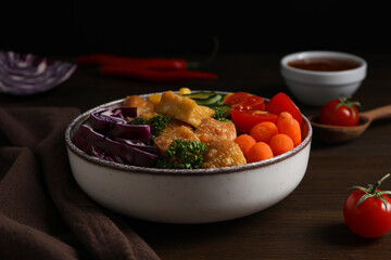 Fried tofu salad on a wooden table