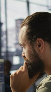 Vertical video System administrator working with machine learning artificial intelligence critical to autonomous systems. Close up of man transforming data into predictive models, camera B