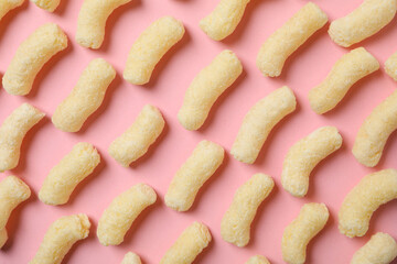 Many sweet corn sticks on pink background, top view