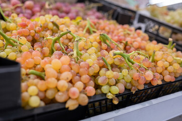A pile of pink Kish-Mish grapes on the store counter. Agriculture, eco-friendly products
