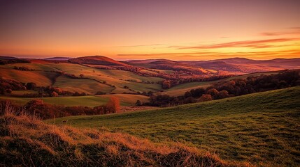A picturesque view of rolling hills and valleys bathed in the golden light of sunset.