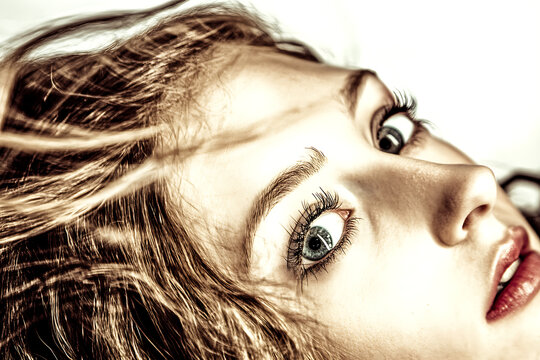 Wide-Eyed Wonder: Close-up portrait of a young woman with wide, inquisitive eyes, captivating the viewer with a sense of curiosity and anticipation.  