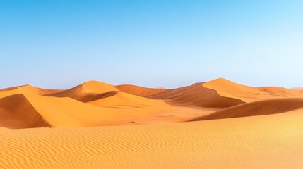 A vast expanse of sand dunes stretches out under a clear blue sky, creating a dramatic landscape.