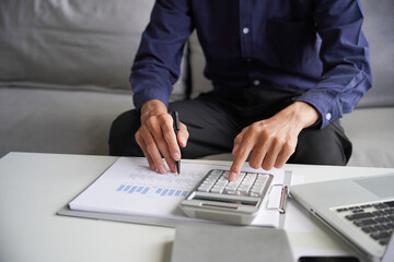 Man using calculator calculate finance and another hand holding pen