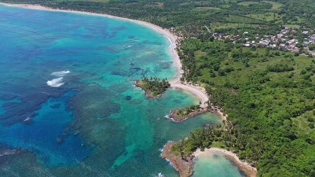 Aerial view tilting backwards over the Playa los Coquitos beach, sunny day in DR