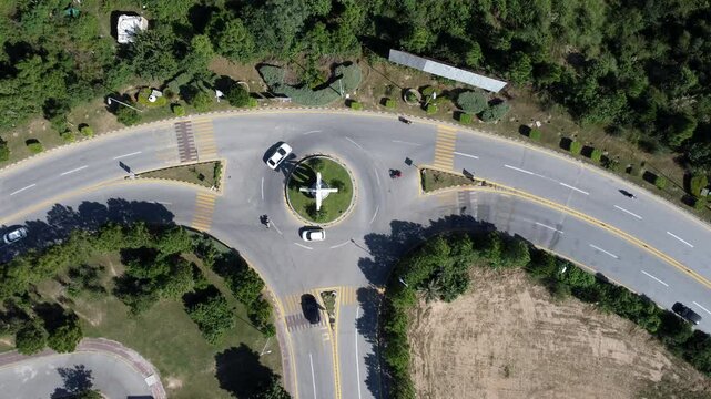 Aerial footage reveals a striking T-shaped roundabout in the jungle, where vehicles navigate the three intersecting roads amidst vibrant greenery.