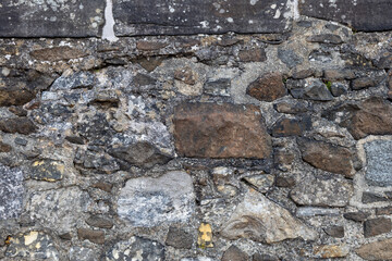 Full frame abstract texture background of a rugged medieval stone wall circa 16th century, with...
