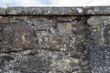 Full frame abstract texture background of a rugged medieval stone wall circa 16th century, with...