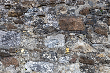 Full frame abstract texture background of a rugged medieval stone wall circa 16th century, with...